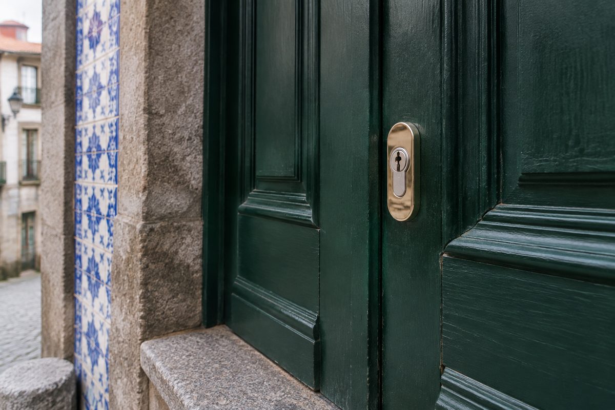 Porta de madeira verde de um prédio antigo do Porto com cilindro novo montado
